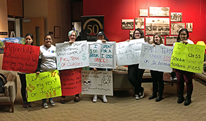 MHCC students with signs at a board meeting